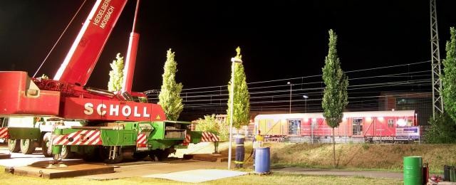 Scholl autokran hebt verlassenen Triebwagen aus dem Gleisvorfeld