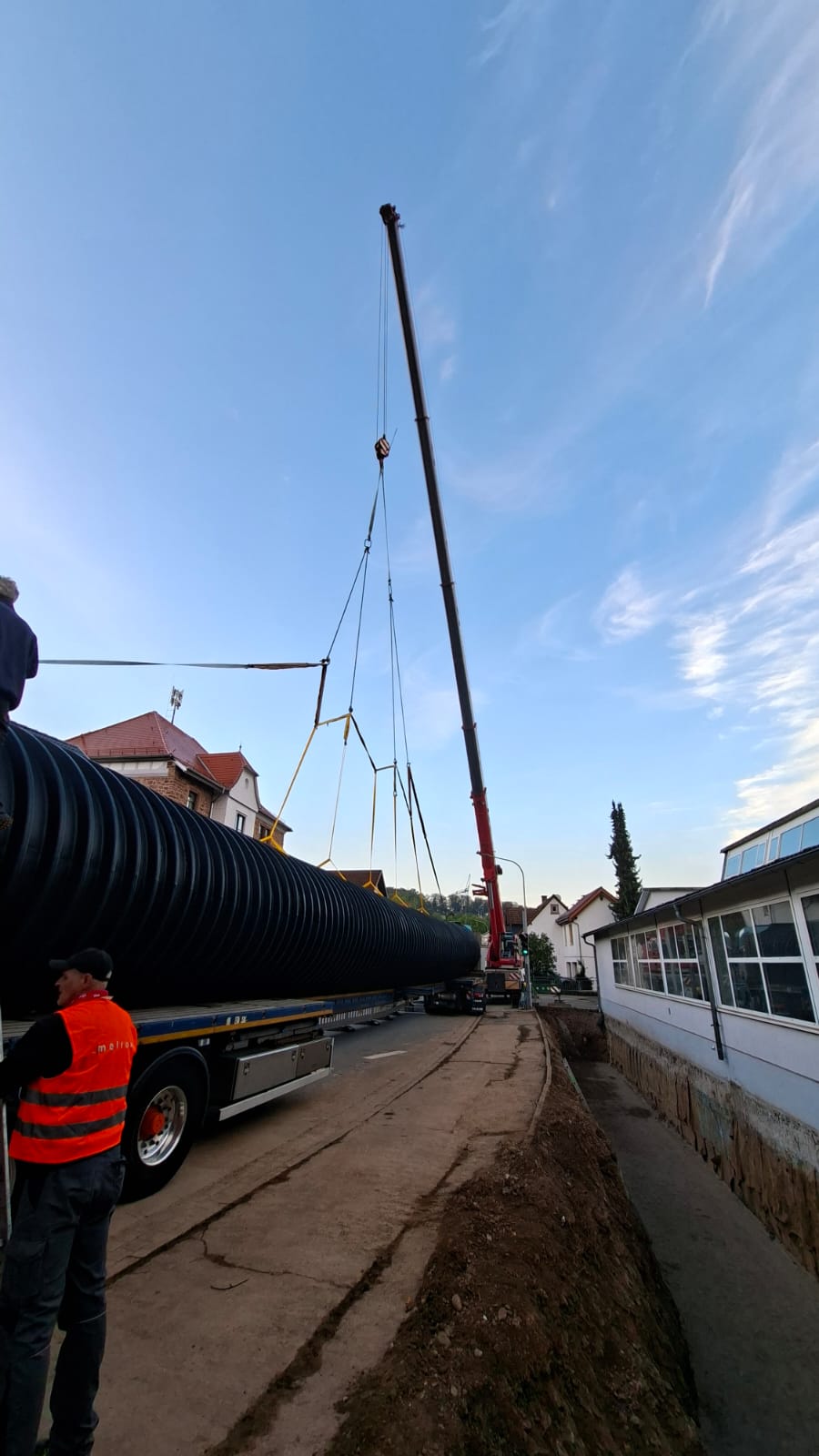 Scholl-Autokran hebt ein Bauteil. Der Kran positioniert die Last präzise über dem abgesperrten Arbeitsbereich.